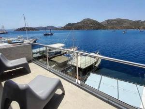 a balcony with a bench and a boat in the water at Buena Vista Hotel&Restaurant in Marmaris