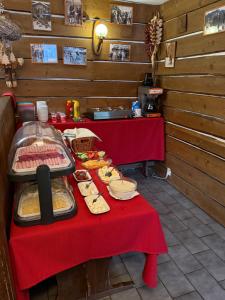 a table with a red table cloth with food on it at Penzion Pažický in Tatranská Lomnica +37 photos