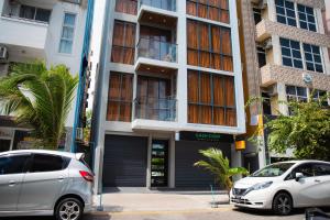 two cars parked in front of a building at Sunrise Stay in Male City