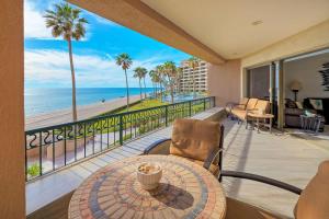 a balcony with a table and chairs and the beach at Beachfront Oasis at Sonoran Spa E201 in Puerto Peñasco