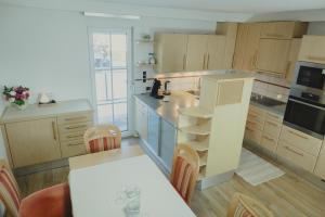 a kitchen with wooden cabinets and a table in it at Ferienhaus am Wildbachberg - Platz für die ganze Familie in Deutschlandsberg