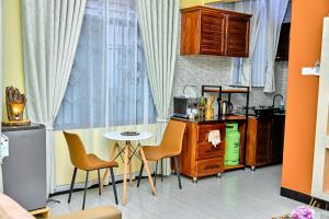 a kitchen with a table and chairs next to a window at Ngao Apartment and Suites Dodoma in Dodoma