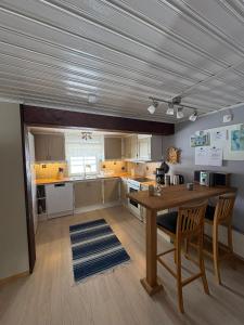 a large kitchen with a wooden table and chairs at Åker Lilläng Strandstugan in Åker