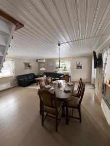 a dining room and living room with a table and chairs at Åker Lilläng Strandstugan in Åker