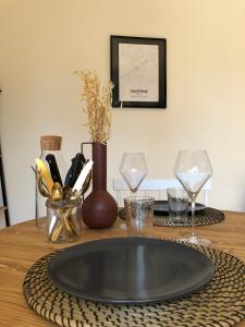 a table with a plate and two glasses on it at Tiny House le Cocon de Jardin in Saverne