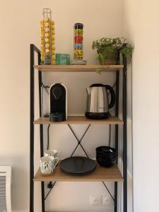 a shelf with a coffee maker and other items on it at Tiny House le Cocon de Jardin in Saverne