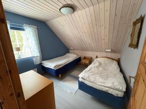 a small room with two beds and a window at Åker Lilläng Strandstugan in Åker
