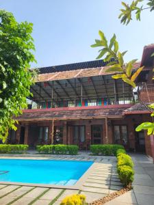 a house with a swimming pool in front of it at Ponyo Stays in Cochin