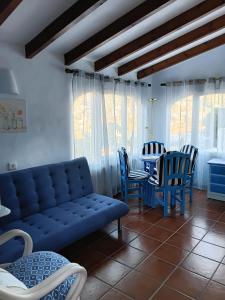a living room with a couch and a table and chairs at Apartamento en Moraira con piscina 100 m de la playa in Moraira
