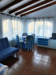 a dining room with a blue table and chairs at Apartamento en Moraira con piscina 100 m de la playa in Moraira