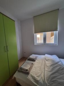 a bedroom with a bed with two towels on it at Stan Duo in Herceg-Novi