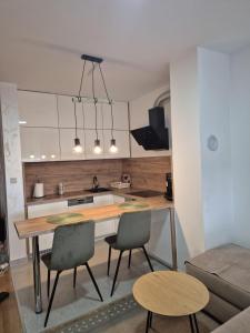 a kitchen with a table and chairs in a room at Muki Oaza Apartman in Tuzla