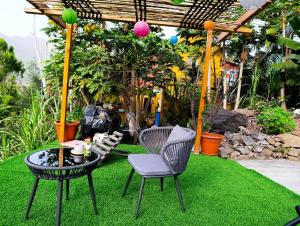 a patio with two chairs and a table on grass at Ecolodge Ribeira Principal in Xá Xá +6 photos