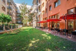 Un patio con mesas, sillas y sombrillas. en Hotel 26, en Berlín