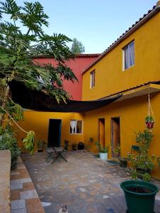 a yellow and red building with a patio in front of it at Ecolodge Ribeira Principal in Xá Xá