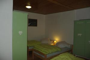 - 2 lits dans une chambre avec des draps verts dans l'établissement Gite d'étape le Belvédère de Sainte-Anne, à Condamine-Châtelard