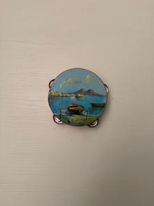 a clock on a wall with a painting of a boat at Da Alfred in Naples
