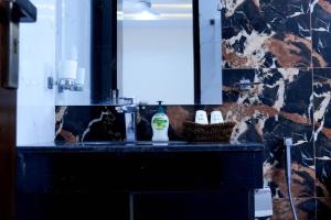 a bathroom with a sink with a mirror and a basket at Zubi Guest House in Dargai +8 photos