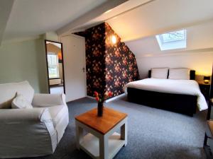 a hotel room with two beds and a couch at Morning Glory, Huisje Dahlia in Beekbergen