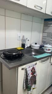 a kitchen with a sink and a stove with a towel at Na Ladeira Studio 01 Rua Miguel Rangel 660 casa 26 in Rio de Janeiro