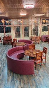 a restaurant with couches and tables and chairs at Pink Mahal Hotel & Resort in Jaipur