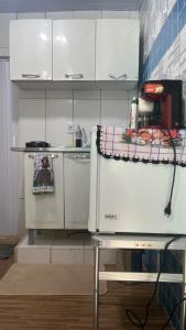 a small kitchen with white cabinets and a counter top at Na Ladeira Studio 01 Rua Miguel Rangel 660 casa 26 in Rio de Janeiro