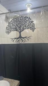 a bathroom with a tree on the shower curtain at Na Ladeira Studio 01 Rua Miguel Rangel 660 casa 26 in Rio de Janeiro
