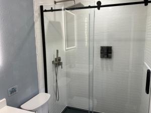 a bathroom with a glass shower with a toilet at Signature Suite in Orlando