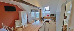 a kitchen with orange walls and a counter with a sink at Le Relais - Appart'Hotel in Düsseldorf