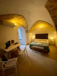 a bedroom with a bed and a desk in a room at Corte della Luce in Ugento