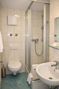 ein Badezimmer mit Dusche, Toilette und Waschbecken in der Unterkunft Hotel Discovery in Stuttgart + 28 Fotos