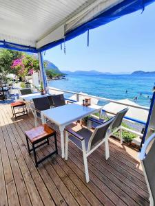 a table and chairs on a deck overlooking the ocean at Mavi Akvaryum Pension in Sogut +47 photos