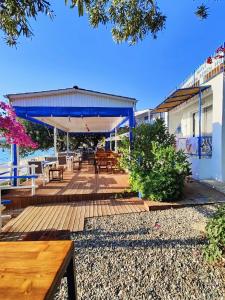 a wooden deck with tables and chairs on the beach at Mavi Akvaryum Pension in Sogut