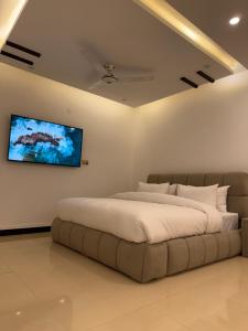 a bedroom with a large bed and a television on the wall at Sunrise Rest House in Islamabad +121 photos