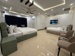 a bedroom with two beds and a flat screen tv at Sunrise Rest House in Islamabad