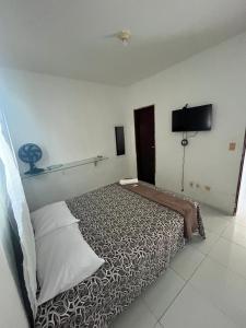 a bedroom with a bed and a flat screen tv at Apartamento simples e Familiar conforto e sossego in João Pessoa
