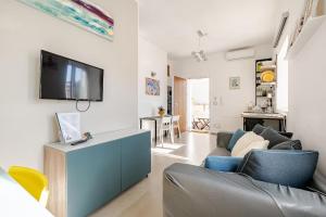 a living room with a couch and a tv on a wall at Studio Alpha - relax e jacuzzi in Syracuse