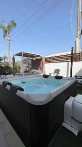 a jacuzzi tub in a backyard with a palm tree at Studio Alpha - relax e jacuzzi in Syracuse