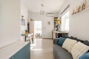 a living room with a couch and a kitchen at Studio Alpha - relax e jacuzzi in Syracuse