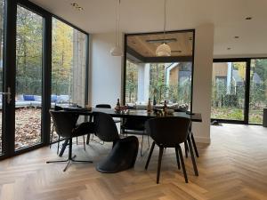 a dining room with a table and chairs at Villa Hogerop in Bennekom +12 photos
