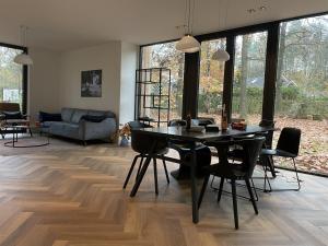 a living room with a black table and chairs at Villa Hogerop in Bennekom
