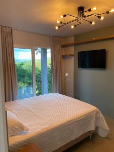 a bedroom with a bed and a large window at Refúgio das Araucárias in Nova Petrópolis