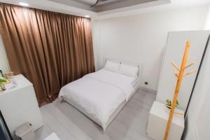 a small bedroom with a white bed and a window at Sunrise Stay in Male City