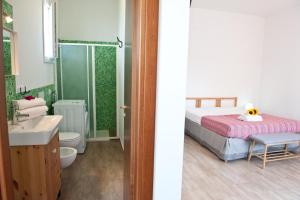 a bathroom with a bed and a toilet and a sink at Corte della Luce in Ugento