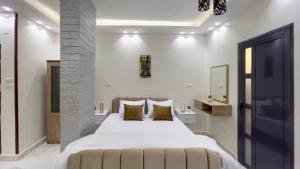 a bedroom with a large white bed with yellow pillows at Casa Pyramids View in Cairo