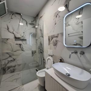a bathroom with a toilet and a sink and a shower at Sunset Boulevard Beach Hotel in Qeparo +20 photos
