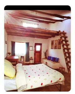 a bedroom with a large bed and a wooden ladder at Faly madatour GH in Antsirabe