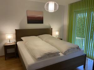 a bed in a bedroom with two lamps and a window at Barrierefreie Ferienwohnung in Bad Windsheim