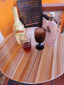 a table with a drink and two bottles of alcohol at EMME Escape in Victoria