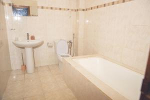 a bathroom with a tub and a sink and a toilet at Pro hébergement in Dakar